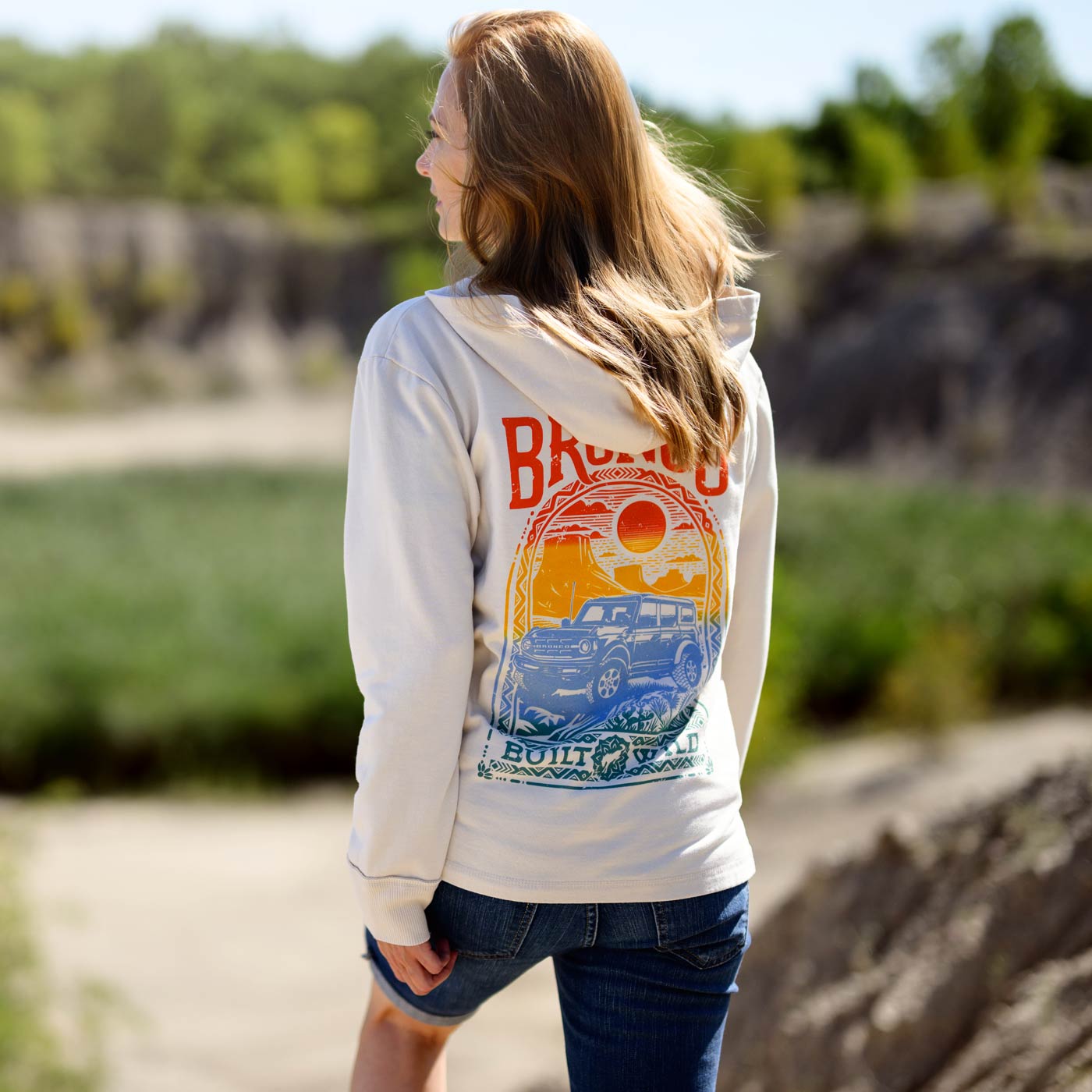Woman wearing a hoodie with a colorful graphic design outdoors