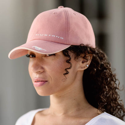 Person wearing a pink cap with 'Mustang' branding against a blurred background