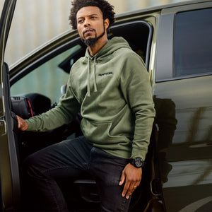 Man in a green hoodie getting out of a ford raptor