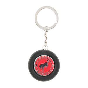 Keychain in the shape of a small tire with a red center and logo on a white background