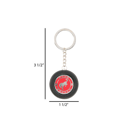 Keychain with a red circular design and measurements on a white background