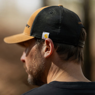 Person wearing a brown and black cap with a Carhartt logo.