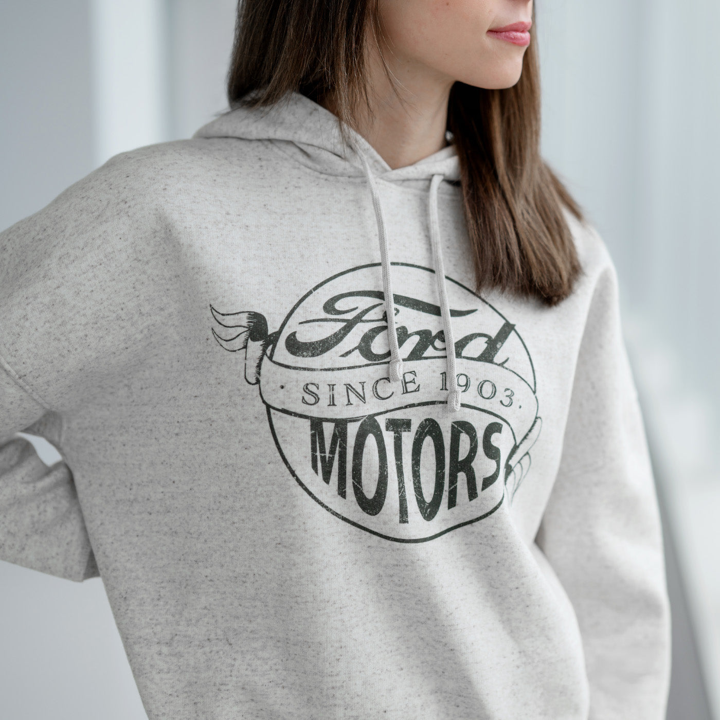Person wearing a gray hoodie with Ford Motors logo