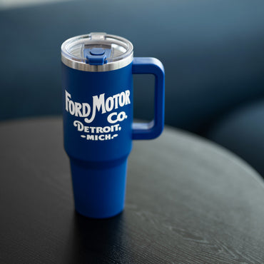 Blue mug with 'Ford Motor Co. Detroit, Mich.' text on a dark surface
