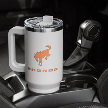 White mug with orange bronco logo in a car cup holder