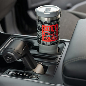 Ford branded tumbler in a car's cup holder with 'Built Ford tough" text.