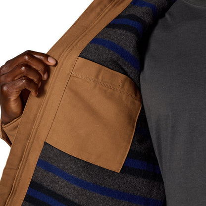 Close-up of a person wearing a brown jacket over a gray striped sweater, with a hand holding the jacket open to show the pocket and lining.