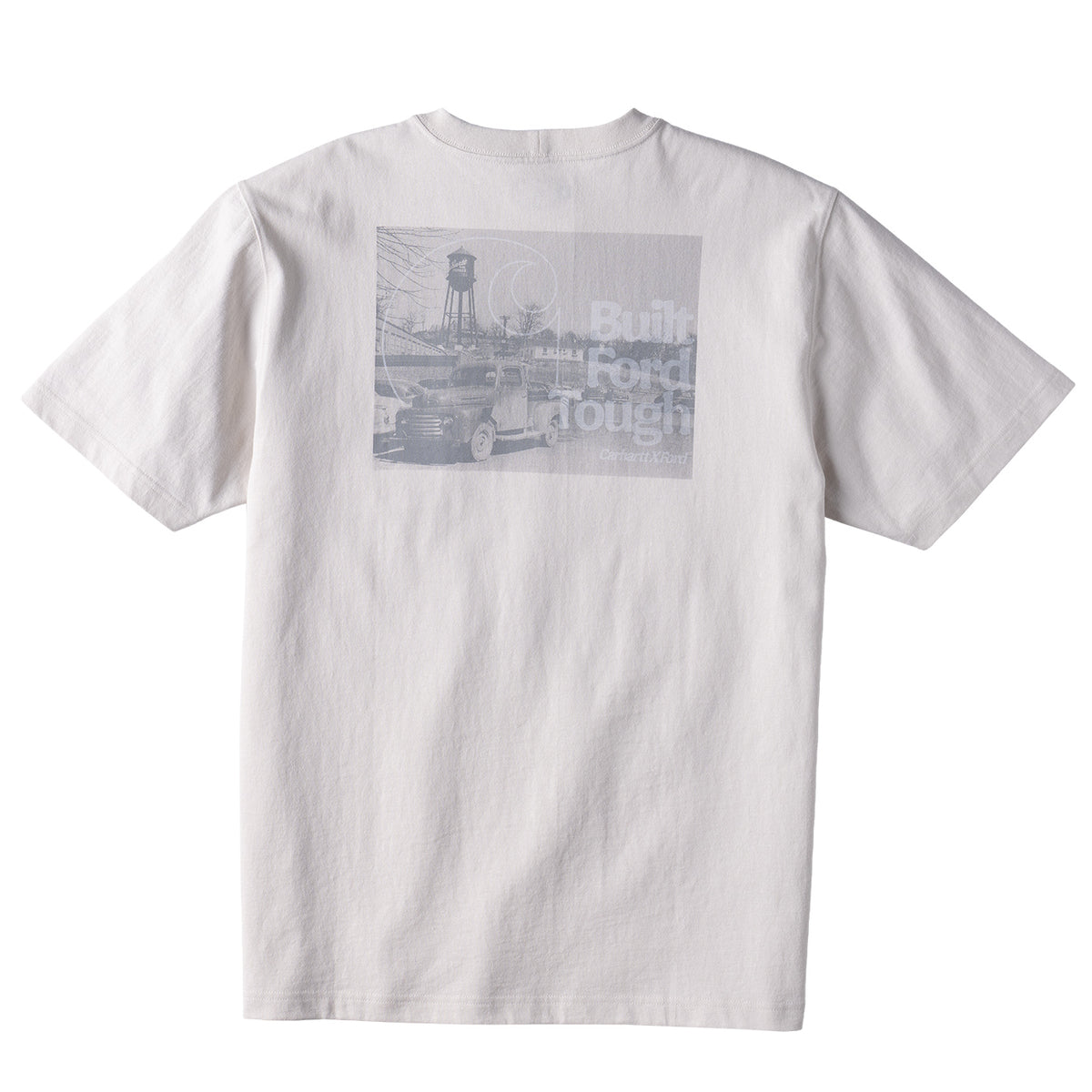 A white short-sleeve crewneck t-shirt shown from the back, featuring a large rectangular gray graphic print on the upper back with a vintage truck, a water tower, and faded text.