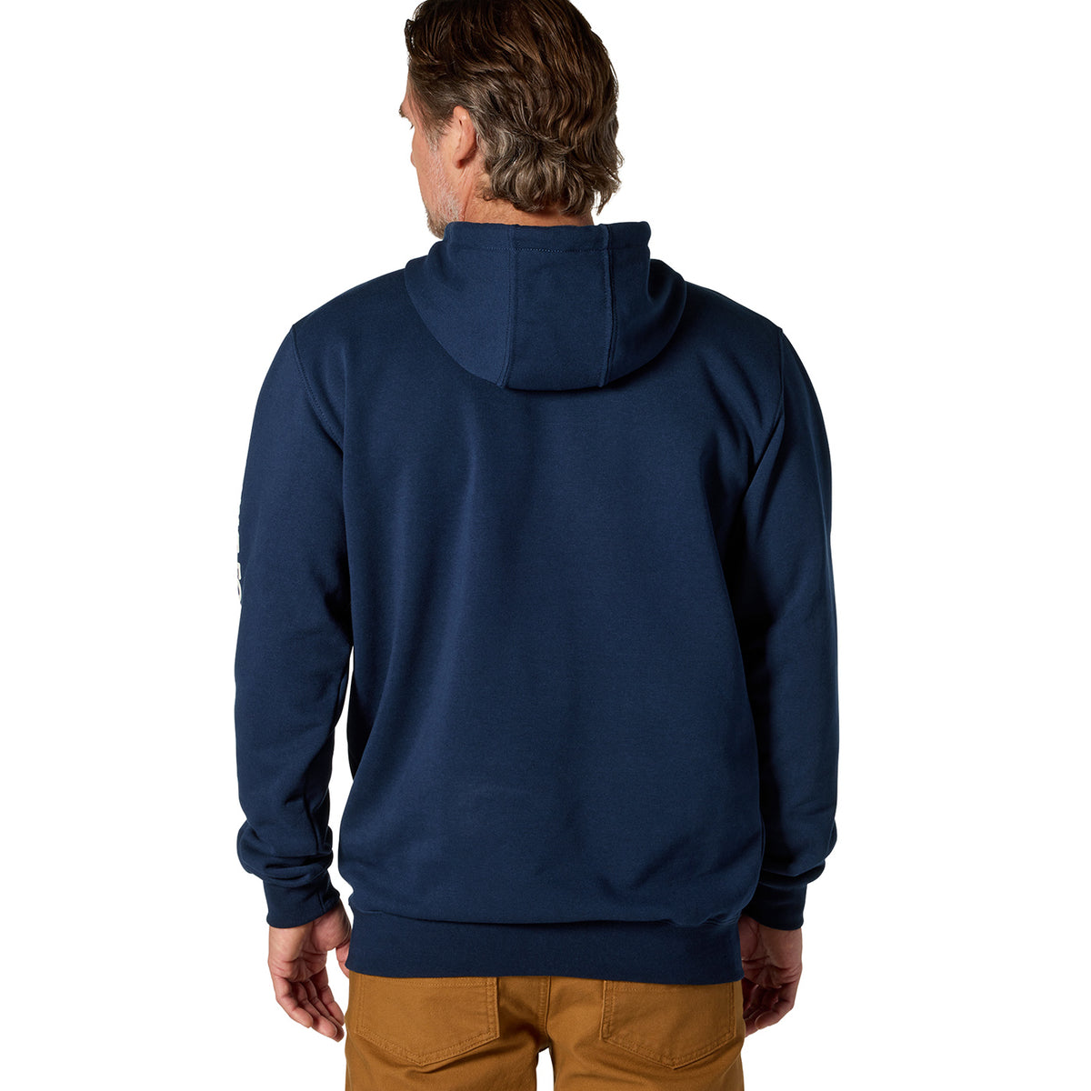 A man viewed from the back wearing a navy blue pullover hoodie and tan pants against a plain white background.