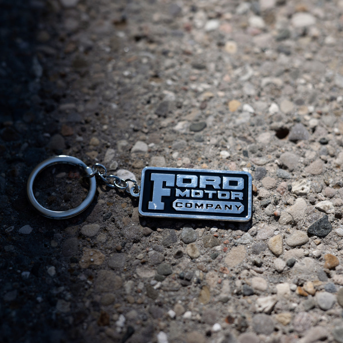 ford motor company keychain on a pebbled background