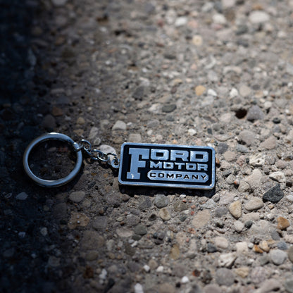 ford motor company keychain on a pebbled background