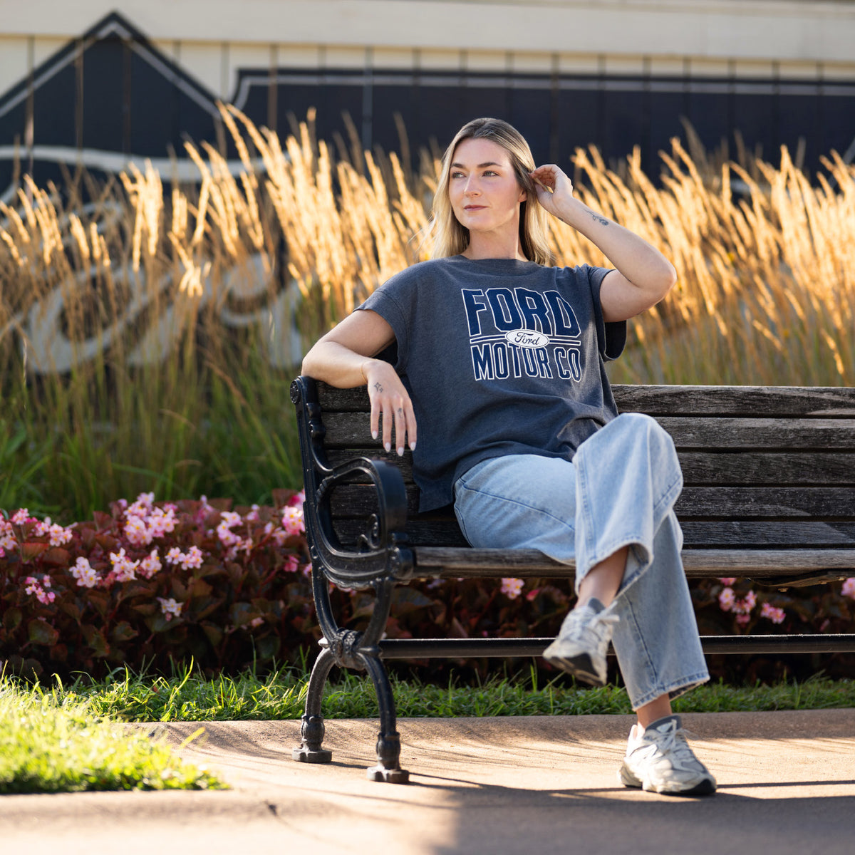 woman sitting on a bench in a ford motor co t-shirt