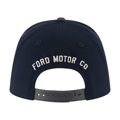 A navy blue snapback cap shown from the back, featuring 'FORD MOTOR CO' embroidered in white arched lettering on the back panel and a dark gray adjustable strap.