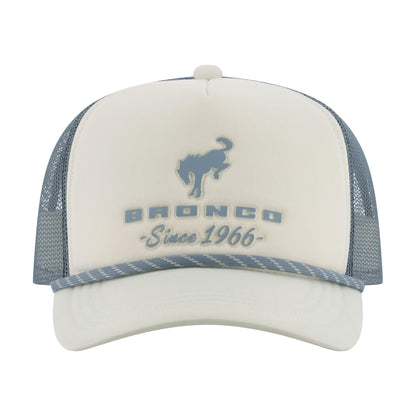 A white and slate blue trucker hat featuring a blue bronco logo and 'BRONCO Since 1966' text on the front panel, with a matching blue patterned visor trim.