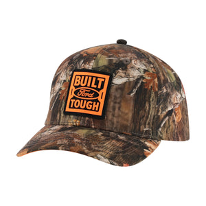 A camouflage baseball cap featuring a prominent orange and black 'Built Ford Tough' patch on the front, set against a plain white background.