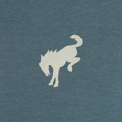 A close-up of a heathered slate blue fabric with a light beige graphic of a horse silhouette.