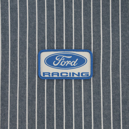 A rectangular embroidered patch with the Ford Racing logo, featuring a blue and white design, placed on a blue and white pinstriped fabric background.