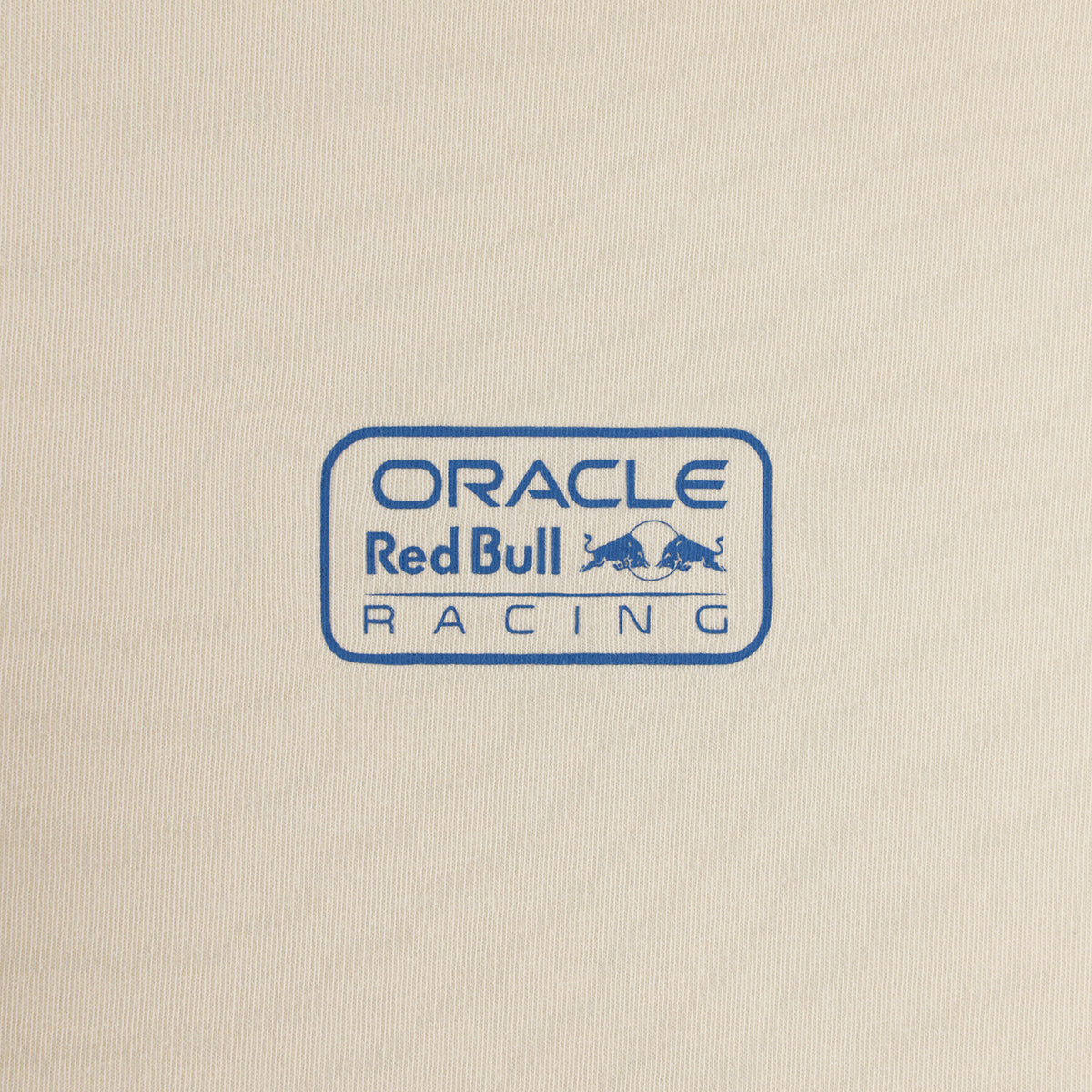 A close-up of a cream-colored fabric surface featuring a blue printed Oracle Red Bull Racing logo.