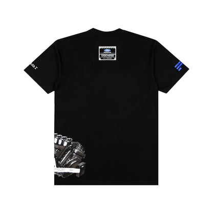 A black short-sleeve t-shirt shown flat against a white background, featuring a detailed engine graphic on the lower left, a small rectangular patch on the upper back, a white graphic on the right sleeve, and blue stripes on the left sleeve.
