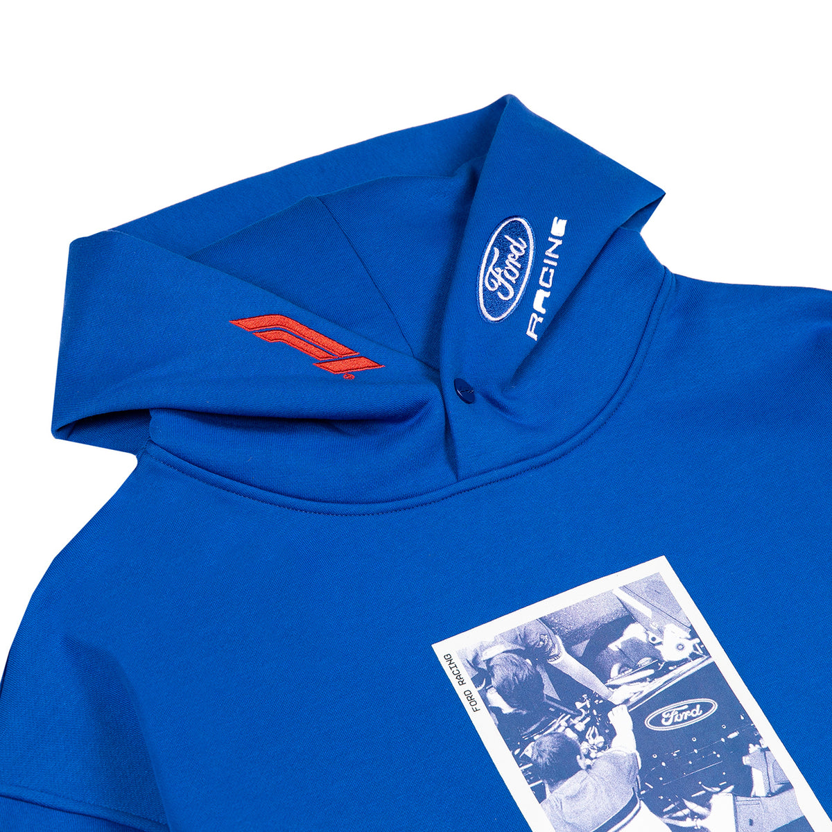 A close-up of a royal blue hooded sweatshirt featuring a red Ford logo on the hood, a white Ford Racing logo on the inside of the collar, and a vintage-style black-and-white photo print on the front pocket.