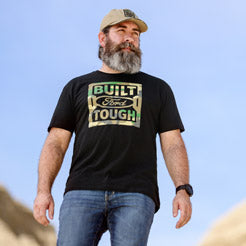Man wearing a black Built Ford Tough t-shirt against a clear blue sky.