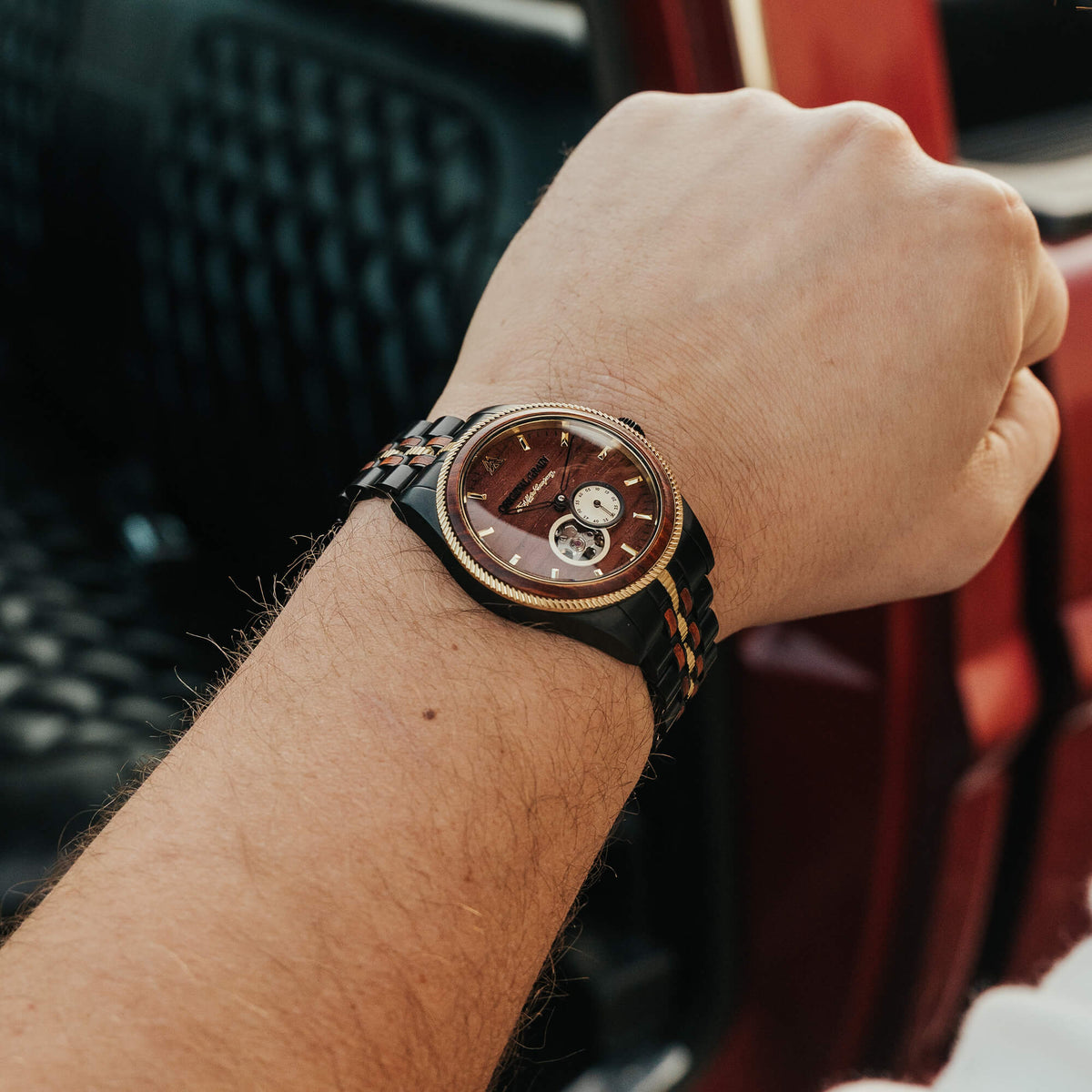 Close-up of a wrist wearing a detailed wristwatch with a blurred background