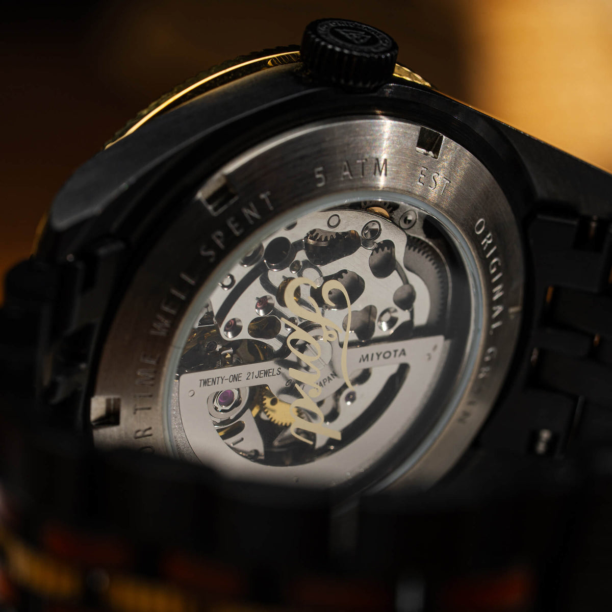 Close-up of a mechanical watch with visible brand name on a blurred background